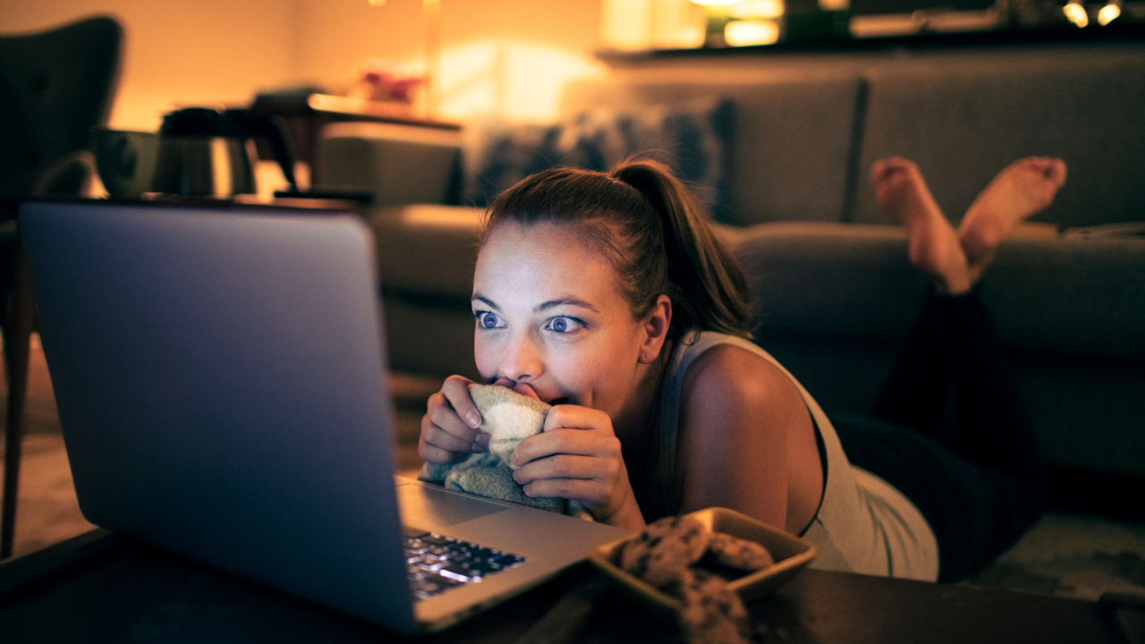 Person watching content on a laptop at home, representing OTT streaming platforms and digital entertainment consumption